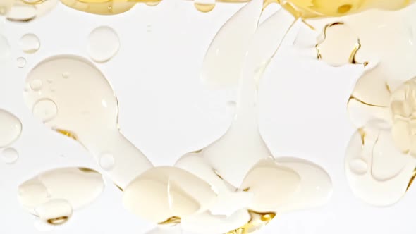 Slow Motion of Moving Yellow Golden Oil Air Bubbles in Water Rising Up on Light White Background