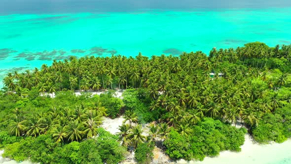 Bright azure lagoon with calm water over coral reefs and rocky seabed surrounding tropical island wi