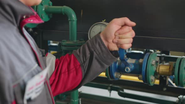 Lever and Pressure Meter with Thin Pipes Near Metal Wall in Brightly Lit Plant Workshop Extreme