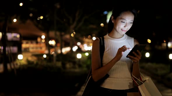 Woman using mobile phone in city 