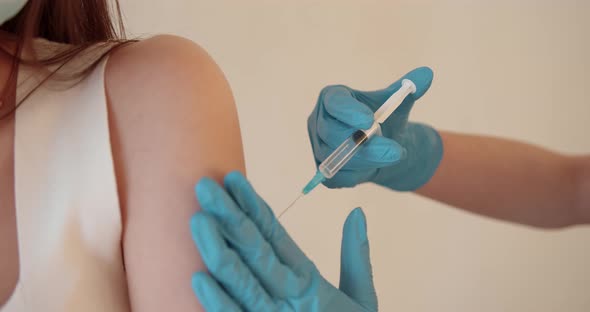 Girl in a Mask Getting Injection on Beige Background