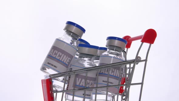 Glass vials for vaccine in shopping cart on white background. Group of vaccine bottles in basket.