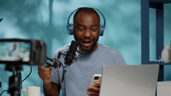 Blogger Reading Good News From Smartphone on Camera