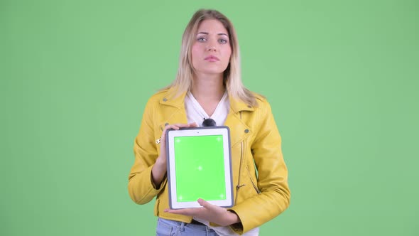 Stressed Young Rebellious Blonde Woman Showing Digital Tablet