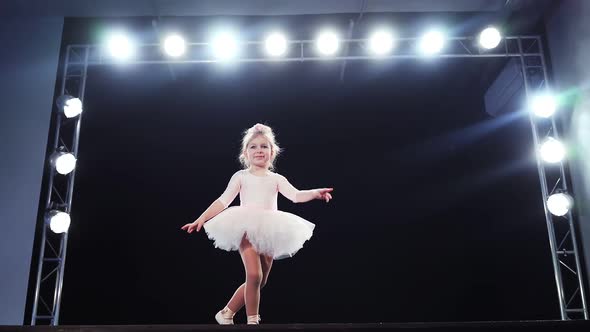 Little Girl Ballerina Caucasian Appearance in a Pink Tutu Dances on Stage