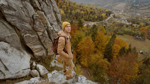 Man Hiker with Backpack Relaxing on Top of a Mountain and Enjoying the View of Valley Tustan Ukraine