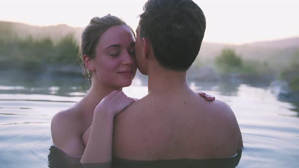 Happy Couple in Love Bathing and Relaxing in Hot Pool in Wild Landscape