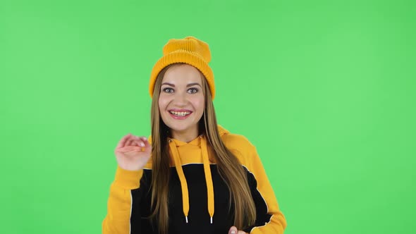 Portrait of Modern Girl in Yellow Hat Is Waving Hand and Showing Gesture Come Here