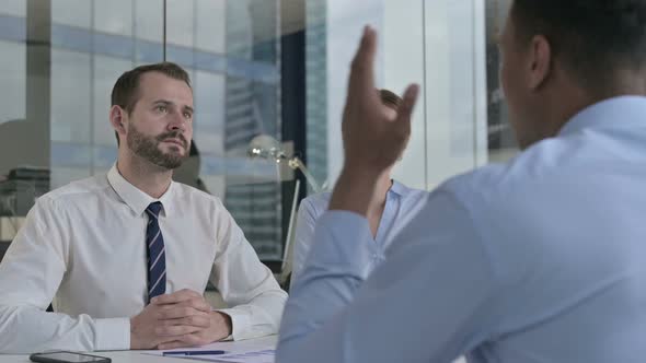 Rear Back View of Guy Having Serious Talk with Business People 