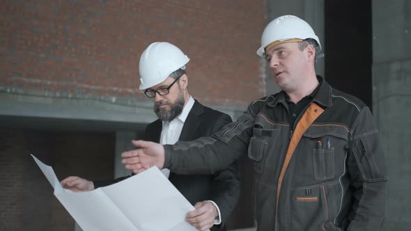 Two Engineers Meet At Construction And Consult Building Project. Two Engineers