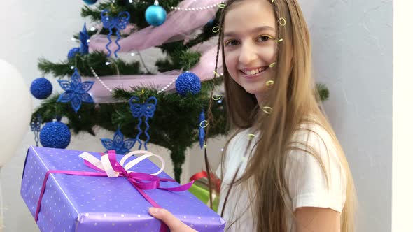 Little Girl of Turkish Appearance Holding a Christmas Present She Laughs Happily
