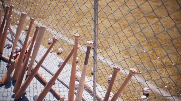 Animation with baseball bats leaning against the fence around the baseball field