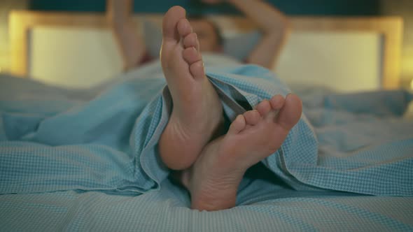 Man is All Over Lying in Bed with His Hands in the Air Waving Them Up and Dancing on His Feet