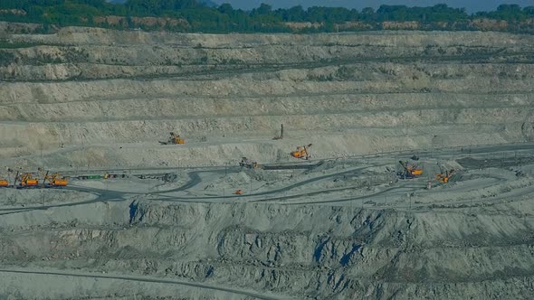 Asbestos Deep Open Pit Ledges with Excavators Against Forest