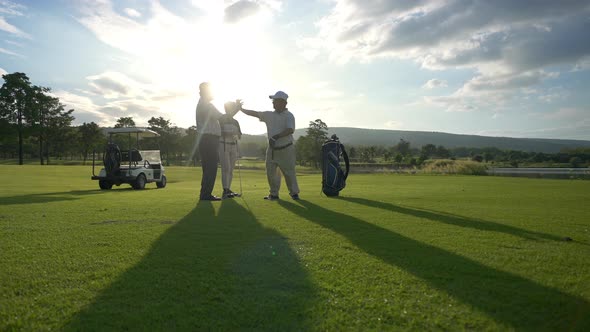 4K Group of Asian men golfer shaking hand after finish the game on golf course at summer sunset