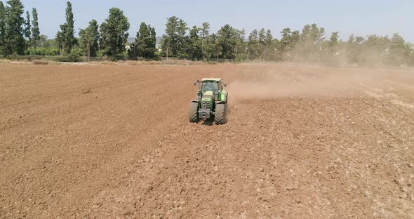 Aerial view of a tractor ploughing an empty field, Kibbutz saar, Israel.