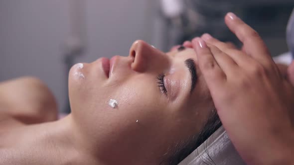 Closeup View of a Woman with Her Eyes Closed Lying on the Couch While Professional Cosmetologist is