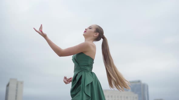 Beautiful Gorgeous Girl in a Stunning Evening Green Dress Dancing Fascinatingly on Empty City Square