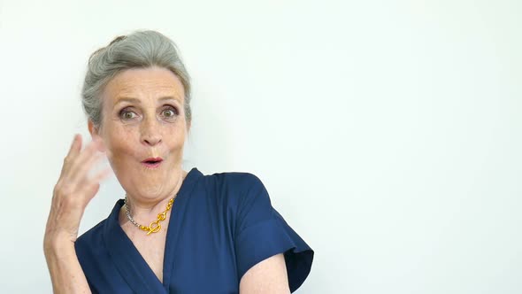 Beautiful Old Funny Grandmother with Grey Hair and Face with Wrinkles is Grimacing While Looking at