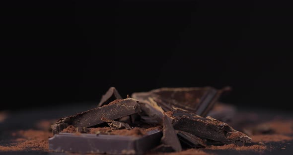 Pieces of Dark Chocolate Swirl on a Black Background