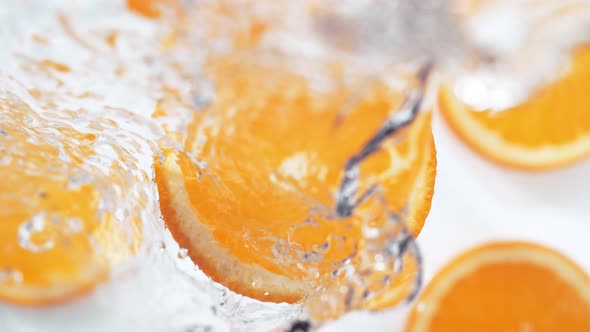 Water splash on sliced orange. Slow Motion.