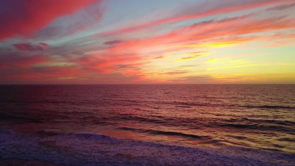 Aerial drone view of a sunset at the beach over the ocean.