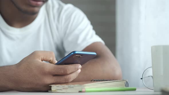 Young Man Hand Using Smart Phone While Sited