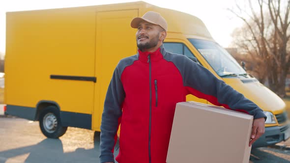 Delivery Boy Carrying A Cardboard Box A Yellow Truck Behind Him  Parcel Delivery