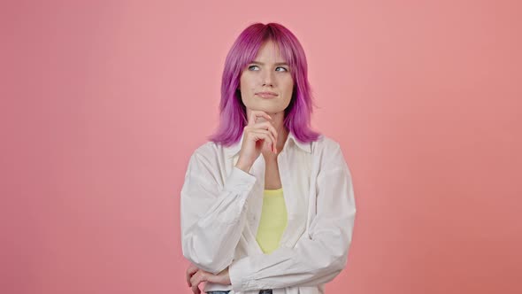 Young Pinkhaired Woman Looks Thoughtful in Pink Studio