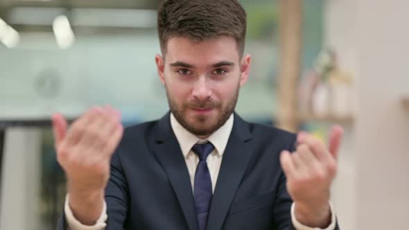 Assertive Young Businessman with Pointing and Inviting