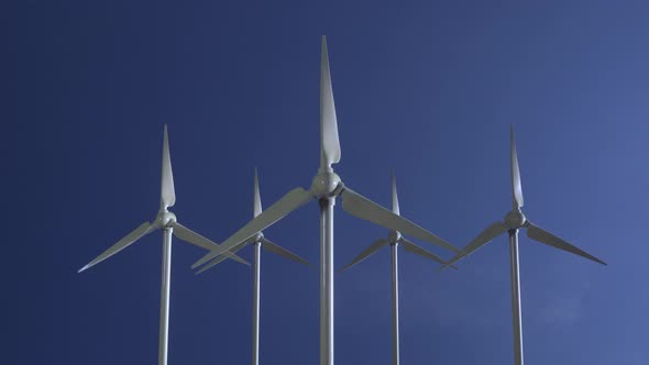 Row of Wind Power Generators on Blue Sky Background