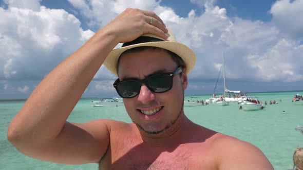 Portrait Young Man in Summer Hat Taking Selfie Video on Catamaran Yacht with Caribbean Sea Water