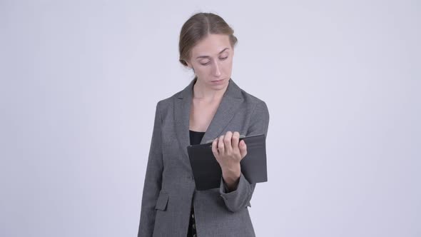 Happy Young Blonde Businesswoman Showing Clipboard and Giving Thumbs Up