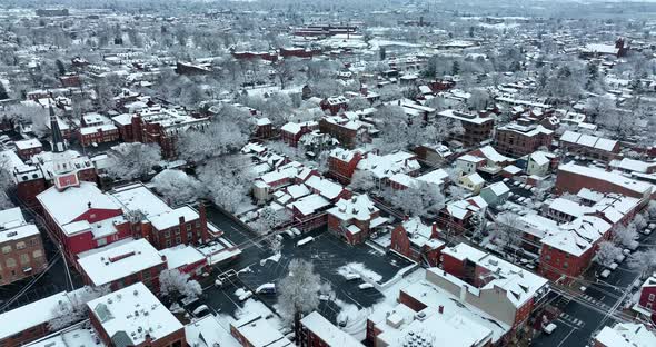 High wide panorama of American town covered in winter snow. Aerial establishing scene. Church steepl