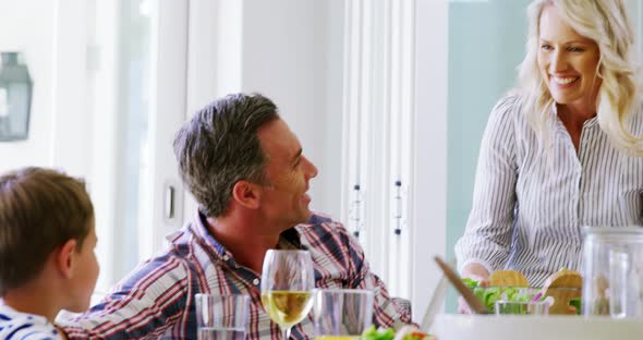 Family interacting while having meal on dining table