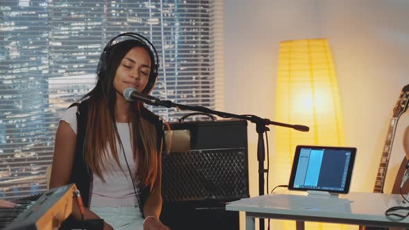 Attractive Mixedrace Girl Emotionally Singing Into Microphone in Home Studio