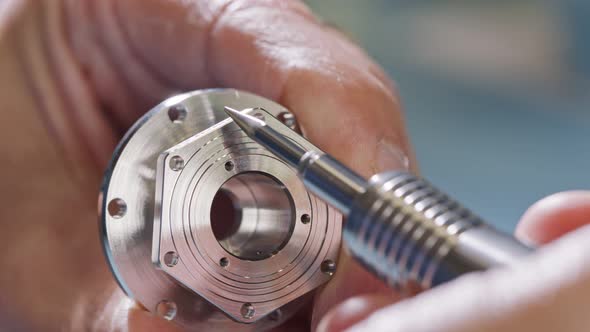 Close up on worker hands during metal part finishing process