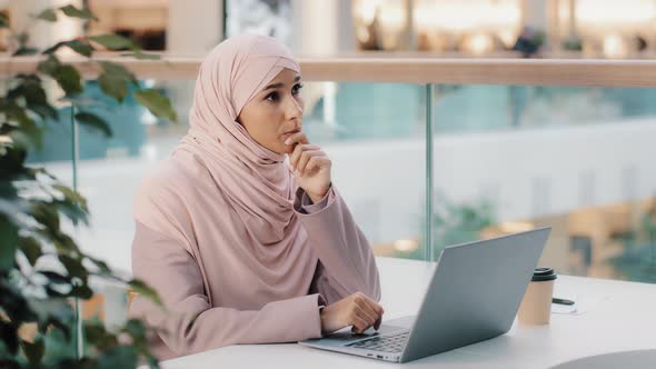 Thoughtful Pensive Worried Young Arab Woman Writer Working on Laptop Thinks New Idea Startup