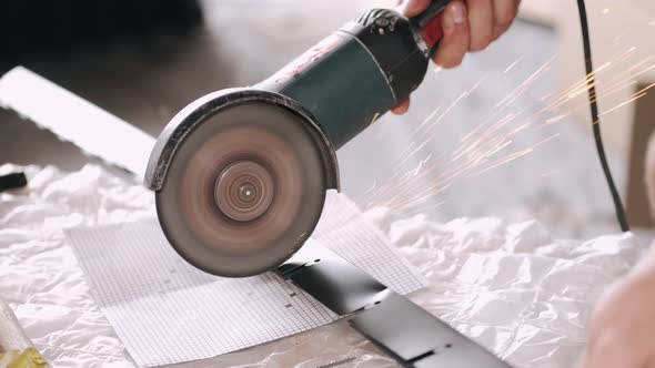 Man Using Angle Grinder For Cutting Metal Profile