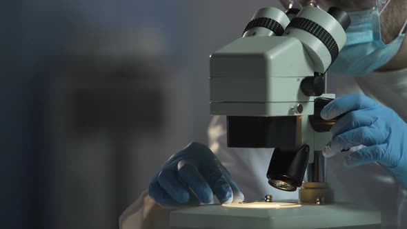 Scientist Adjusts Microscope to See Cell Molecular Compound, Microbiology
