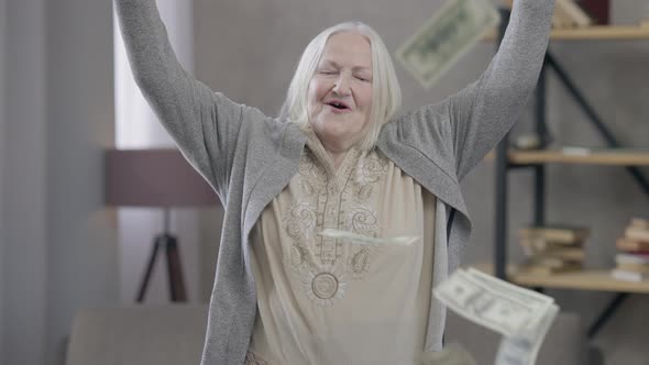 Cheerful Rich Old Caucasian Woman Throwing Money Falling in Slow Motion