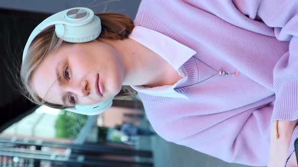 Melancholic Lady Student in Earphones Listens to Music