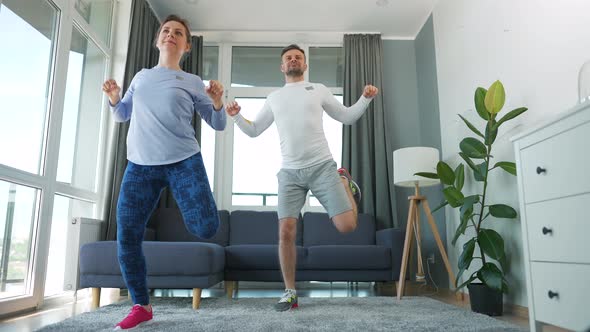 Caucasian Couple is Doing Cardio Exercise at Home in Cozy Bright Room Slow Motion