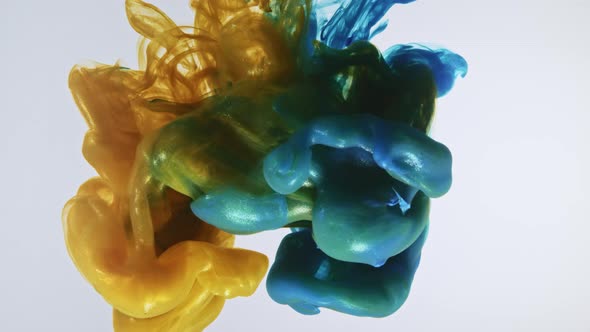 Colorful nacreous paint in water against white background. alt