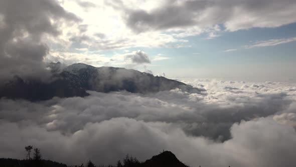 High Snowy Mountains Between Two Layers of Above Clouds