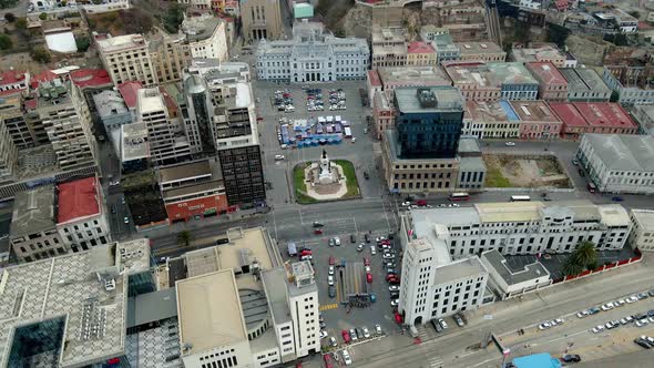 Aerial orbit of buildings and cars driving in the streets surrounding Plaza Sotomayor, civic center