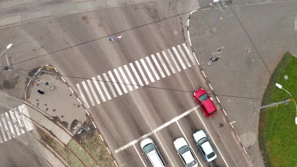 Cars Move Through Crosswalk Near Large Intersection City  Drone Overhead Zoomin Shot