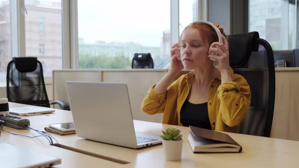 Woman Working On Laptop In Headphones