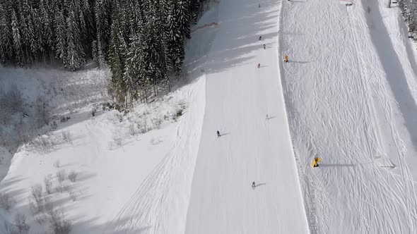 Aerial Ski Slopes with Skiers and Ski Lifts on Ski Resort. Snowy Mountain Forest