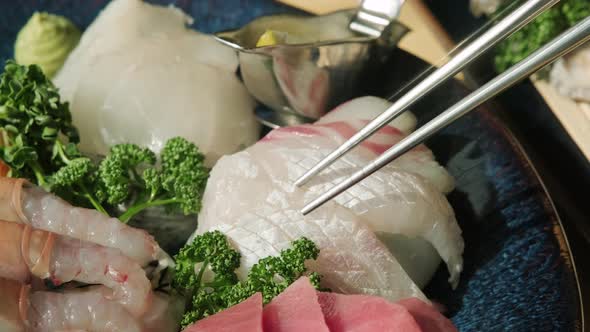 Fresh Japanese sashimi lifted with chopsticks